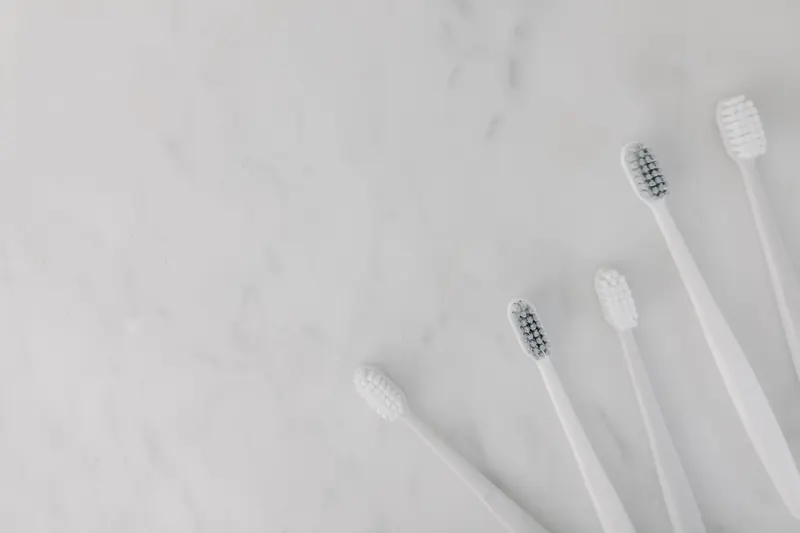 Elegant display of white toothbrushes on a marble surface, emphasizing hygiene and simplicity